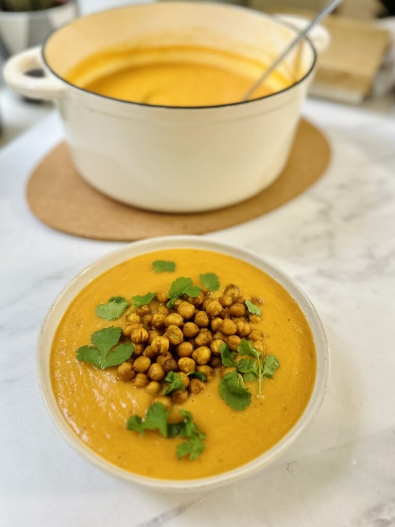 creamy sweet potato soup with crunch chickpeas in a large pan