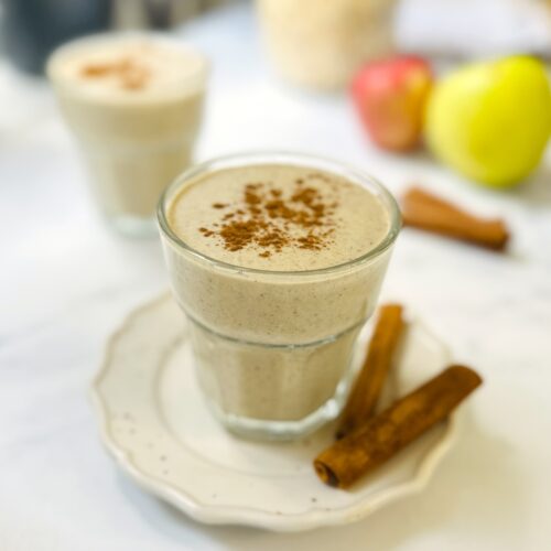 apple pie smoothie in a glass with cinnamon sticks