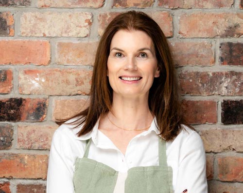 Nutritionist Helen Ridgeway facing camera wearing green apron and white shirt