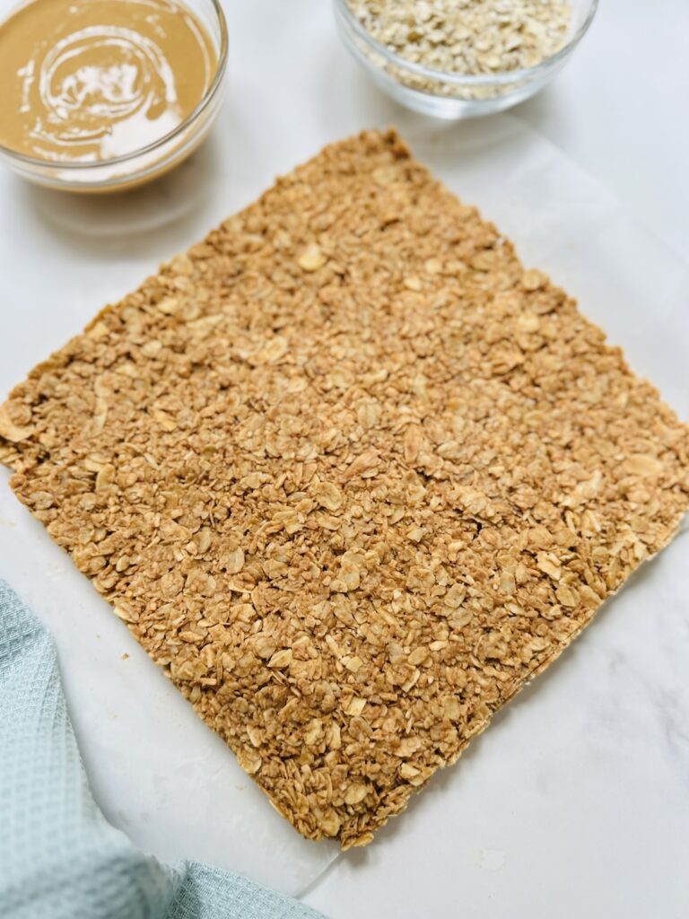 no bake oat bars with coconut and almonds uncut on a board