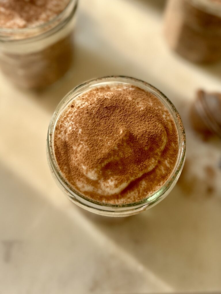 mocha overnight oats in a jar with yoghurt n top and cacao dusting overheat shot