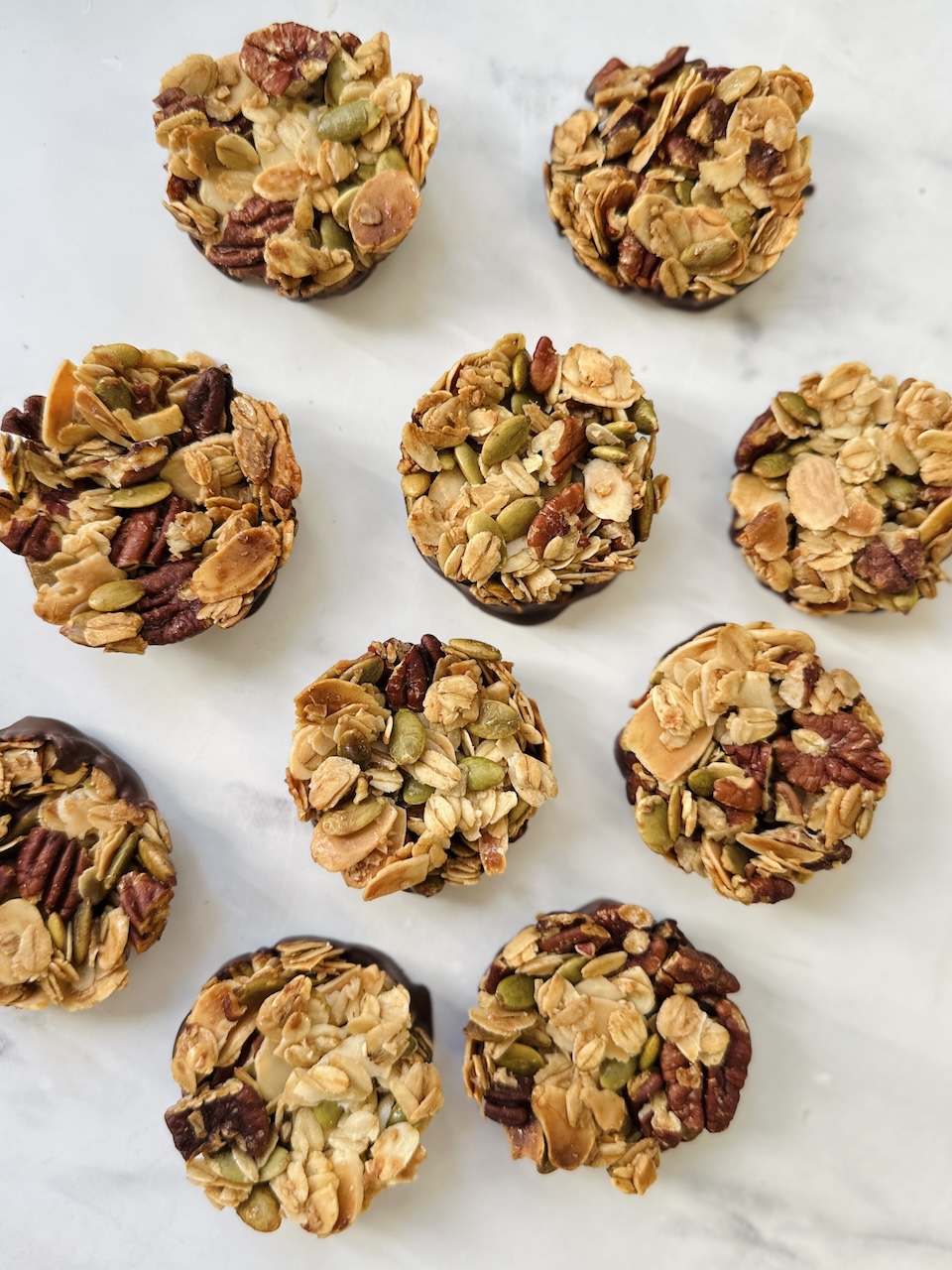 nut clusters on a marble background made with pecans, almonds and pumpkin seeds